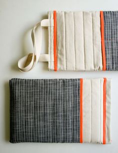 two pieces of cloth with orange and white trims on the sides, sitting next to each other