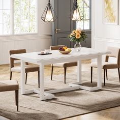 a white table with chairs around it and a bowl of fruit on the dining room table