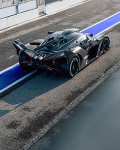 a black sports car driving down a race track