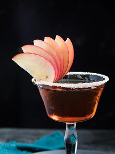 an apple sitting on top of a glass filled with liquid