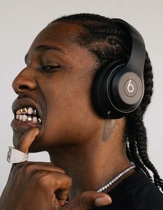 a man with dreadlocks and headphones on his ear is making a funny face