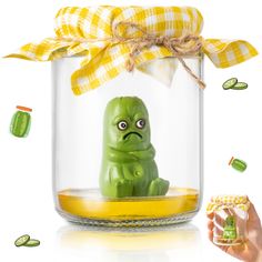 a glass jar with a green toy in it