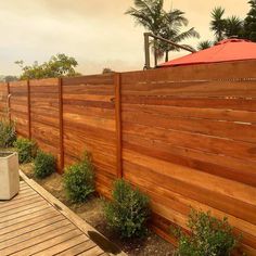 a large wooden fence next to some plants