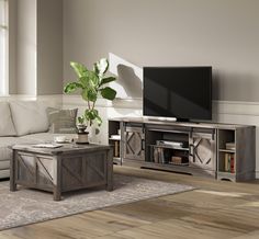 a living room with a couch, coffee table and television on top of the entertainment center