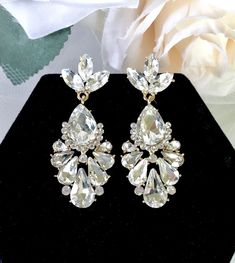 A delightfully unique pair of bridal earrings with an incredible sparkle! Lightweight, the earrings are adorned with flawlessly faceted rhinestone crystals that capture the light in a dazzling array of sparkles, and are rhodium/gold plated for a bright finish which enhances the intricate detailing and conveys a modern take on old elegance. Length: 2" (approx. 5cm). Available in Silver and Yellow Gold finishes. To make your choice select your preferred finish from the dropdown menu. Hypoallergeni Glamorous Diamond Earrings With Sparkling Stones For Wedding, Diamond White Cubic Zirconia Chandelier Earrings For Party, Glamorous Sparkling Diamond Earrings For Wedding, Glamorous Sparkling Diamond Wedding Earrings, Glamorous Diamond Drop Bridal Earrings, Glamorous Sparkling Diamond White Chandelier Earrings, Glamorous Diamond White Crystal Earrings For Wedding, Glamorous Crystal Diamond Earrings For Wedding, Dazzling Diamond White Teardrop Crystal Earrings