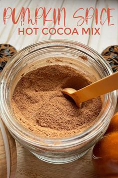 pumpkin spice hot cocoa mix in a glass jar with an orange peel on the side