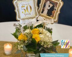 a vase filled with yellow and white flowers on top of a table next to candles