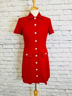 "This adorable red and white mini dress has a full button front closure with short sleeves and pockets. Super sweet white stitching on the pockets and collar. Dress is fully lined. This would be a great all around dress.  Measurements taken laying flat: Shoulders 15\" Bust 17.5\" Waist 15.5\" Hips 18.5\" Sleeve length 7.5\" Length(from shoulder to hem) 33.5\" Label Talbots Petites size 2P  Dress fits more like a size 4-6,but please refer to measurements." Fitted Short Sleeve Dress With Buttoned Pockets, Fitted Dress With Buttoned Pockets And Short Sleeves, Vintage Knee-length Mini Dress With Button Closure, Classic Short Sleeve Mini Dress With Buttons, Classic Mini Dress With Buttons And Short Sleeves, Classic Collared Mini Dress With Buttons, Vintage Mini Dress With Button Closure, Retro Mini Dress With Button Closure, Fitted Collared Dress With Buttoned Pockets