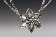 a silver flower necklace on a chain