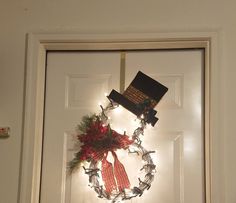 a lighted wreath on the front door of a house