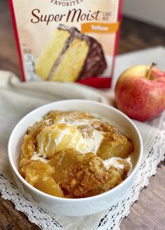 a white bowl filled with food next to an apple on top of a wooden table