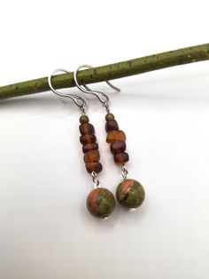 An earthy forest-inspired bohemian pair of silver dangle earrings; crafted with stainless steel French hooks, 4 mm polished unakite stone, brown sea glass, and a beautiful polished green unakite stone. *Handmade by me, one of a kind. *Length: 6 cm *Diameter of largest stone: 10 mm *Crafted with silver stainless steel hypoallergenic hooks.  Nickel free. Click on the link below if you would like to see more artisan jewelry and unique artwork! https://www.etsy.com/shop/CailinCreatesCo I try my best to accurately portray the details in all of my jewelry. Please note that colors may vary due to lighting conditions, camera settings, and variations in computer monitor or phone display settings. If you have any questions regarding any items I have available, please do not be afraid to reach out! Adjustable Earthy Dangle Earrings, Earthy Dangle Earrings With Ear Wire, Bohemian Amber Drop Earrings, Handmade Amber Bohemian Earrings, Bohemian Amber Earrings With Ear Wire, Handmade Bohemian Amber Earrings, Earthy Drop Earrings With Natural Stones, Earthy Style Drop Earrings With Matching Set, Bohemian Amber Dangle Earrings