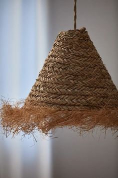 a woven light shade hanging from a ceiling