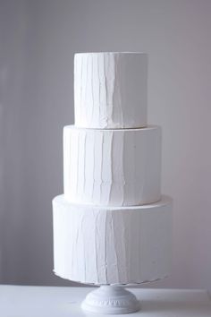 a three tiered white cake sitting on top of a table