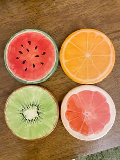 three slices of watermelon, orange and grapefruit on a wooden table