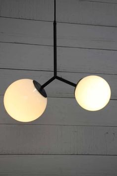 three lights hanging from the ceiling in a room with wood paneling and white walls