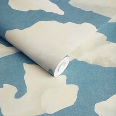 a blue and white wallpaper with an animal pattern on it's side, next to a roll of tape