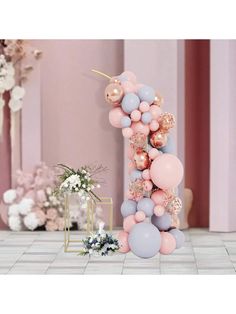 balloons and flowers are arranged on the floor in front of a wall with pink walls