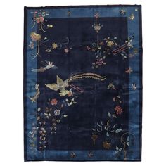 a blue rug with birds and flowers on it