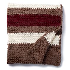 a crocheted blanket is laying on top of a white surface with red and brown stripes