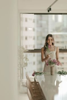 a woman standing in front of a table with flowers