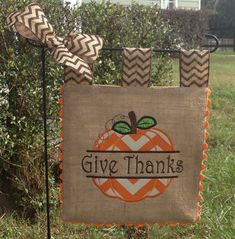 a burlocked sign that says give thanks with an orange pumpkin on it