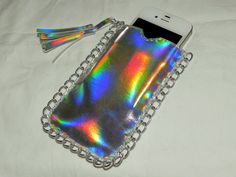 a cell phone case that is sitting on a white sheet with chains and tassels