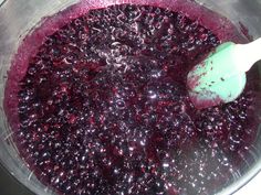 blueberry sauce in a blender with a green spoon