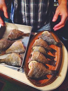 a tray with fish on it being prepared to be eaten by someone in the kitchen