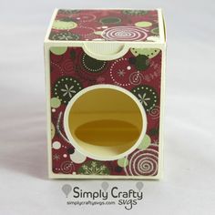 a small cardboard box that has a cup in it and is decorated with floral designs