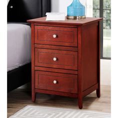 a wooden night stand with three drawers and a blue lamp on the top of it