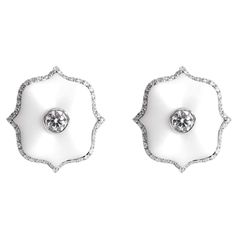 A pair of platinum Mini Lotus ear clips each centered upon a round brilliant-cut colorless diamond set in matte white ceramic with a colorless diamond micropavé surround. Exquisite White Platinum Earrings, Elegant White Platinum Earrings, Luxury Diamond White Earrings With Pave Setting, Exquisite White Diamond Earrings For Evening, Luxury White Earrings With Single Cut Diamonds, White Luxury Earrings With Single Cut Diamonds, Luxury Platinum Diamond Earrings With Accents, Luxury Diamond Earrings With Halo Design, Luxury Platinum Diamond Earrings With Halo Design