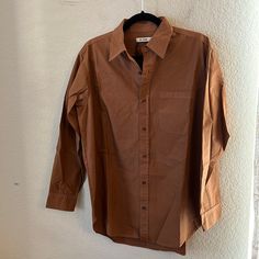 Re/Done 90s Oversized Shirt Color: Ginger Size: Small Nwt 100% Cotton Button Down With Pocket Pit To Pit 23” Waist Length 31” Oversized Brown Shirt With Button Closure, Oversized Brown Shirt For Workwear, Oversized Brown Shirt For Spring, Oversized Brown Cotton Blouse, Oversized Brown Tops For Work, Brown Oversized Button-up Blouse, Brown Oversized Button-up Top, Oversized Brown Collared Blouse, Oversized Brown Tops With Buttons