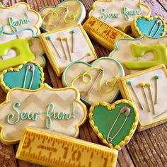 some decorated cookies are sitting on a wooden table with scissors and measuring tape around them