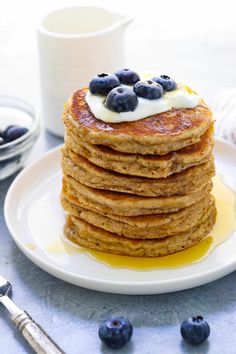 stack of pancakes with blueberries and cream on top