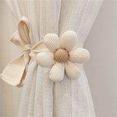 a white curtain with a flower attached to it