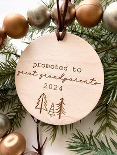 a wooden ornament hanging from a christmas tree with ornaments around it and the words,