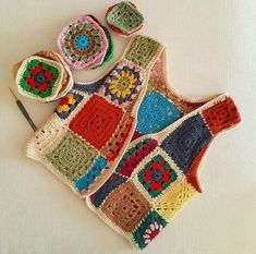 a crocheted blanket, potholder and two bowls on a white tablecloth