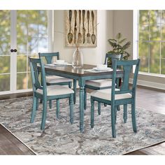 a dining room table with chairs and a rug