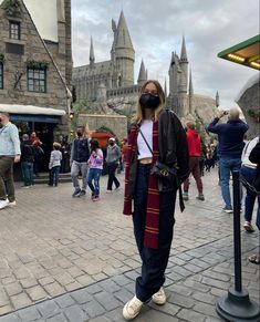 a woman wearing a face mask while standing in front of hog potter's castle