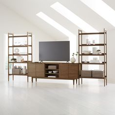 an empty living room with a large tv and shelves on the wall in front of it