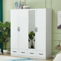 a white armoire with two doors and some plants in the corner next to it