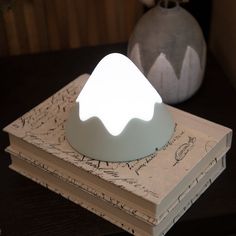 a white light sitting on top of a stack of books