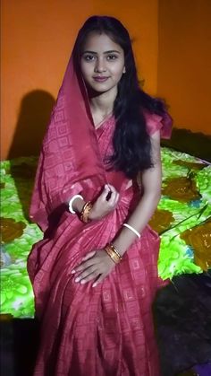 a woman in a pink sari poses for a photo