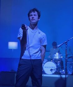 a man standing in front of a microphone on stage