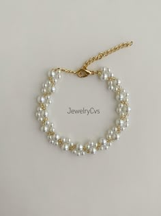 a bracelet with pearls and gold chains on a white background, the bead is attached to