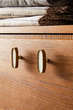 two wooden drawers with knobs on them and towels in the backgroung