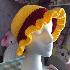 a crocheted hat with yellow and red trim