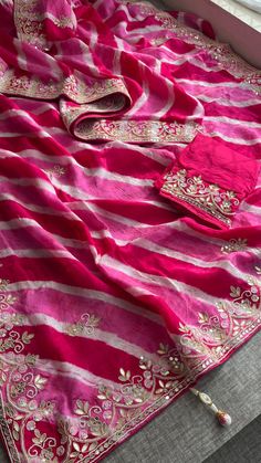 This beautiful Leheriya saree, crafted from 100% pure soft tussar silk, showcases the timeless charm of traditional design. Adorned with intricate Gota Patti work along with zardozi, sequins, and pearl embellishments, it is a masterpiece of craftsmanship. Perfect for festive and celebratory occasions, this saree brings elegance and sophistication to your ethnic wardrobe. Fabric of Saree: 100% Pure Soft Tussar Silk Leheriya Work: Gota Patti, Zardozi, Sequins & Pearl Care: Dry Clean Only *Product Pink Raw Silk Saree With Dori Work, Pink Raw Silk Saree With Gota Work, Festival Banarasi Silk Pre-draped Saree With Gota Work, Navratri Silk Saree With Gota Work, Unstitched Art Silk Saree With Gota Work, Pink Raw Silk Saree With Dupatta, Pink Chanderi Saree With Gota Work, Semi-stitched Silk Saree With Gota Work, Diwali Silk Saree With Gota Work