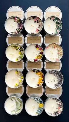 twelve tealight candles are arranged in small trays with floral designs on the lids